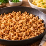 Browned plant-based TVP crumbles in a skillet, illustrative cooking suggestion
